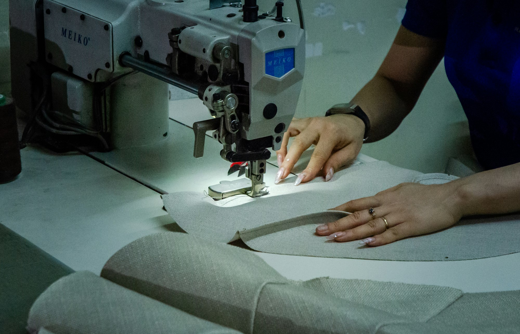 Industrienähmaschine näht einen grauen Polsterstoff